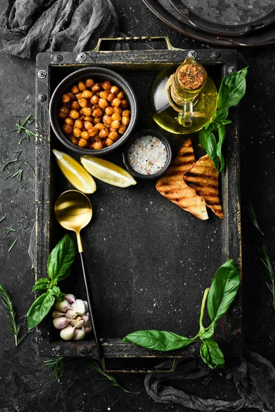 Cooking background: chickpeas, spices, and herbs. On a concrete background. Top view.
