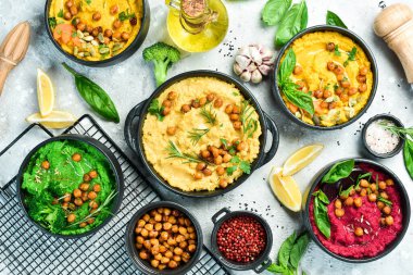 Humus kaseleri arka planda. Geleneksel humus, bitki humusu, pancar humusu. Beton gri arka planda. Üst görünüm.