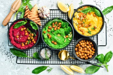 Humus kaseleri arka planda. Geleneksel humus, bitki humusu, pancar humusu. Beton gri arka planda. Üst görünüm.