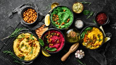 Renkli humus kaseleri. Çeşitli vejetaryen soslu humuslar. Beton bir arka planda.