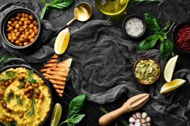 Nohut ve havuçtan yapılmış humus, zeytin yağı ve baharatla birlikte. Üst Manzara. Siyah bir arkaplanda.