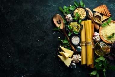 Pesto soslu makarna ve kurutulmuş domates. İtalyan geleneksel mutfağı. Siyah taş arka planda.