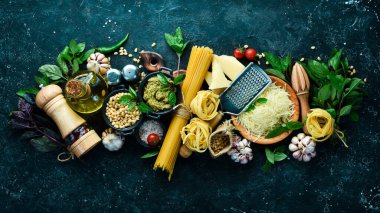 Pesto soslu makarna ve kurutulmuş domates. İtalyan geleneksel mutfağı. Siyah taş arka planda.