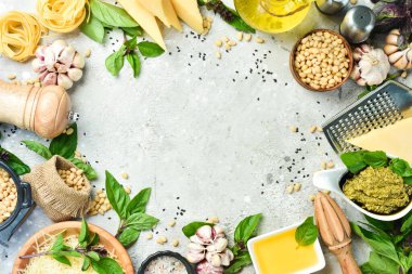 Pesto sosu hazırlığı. Fesleğen, çam fıstığı, parmesan ve zeytinyağı. Gri beton arka planda.