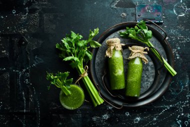 Cam şişelerde kereviz suyu ve bir tutam taze kereviz. Sağlıklı beslenme. Metin için boş alan.