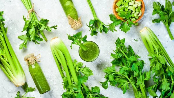 Green celery stalk and celery juice on gray stone background. Vegetarian drink. Free space for text.
