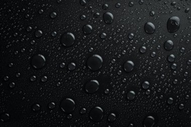 - Su. Siyah zemin ve yağmur damlaları. Makro. Üst görünüm.