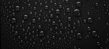 - Su. Siyah zemin ve yağmur damlaları. Makro. Üst görünüm.