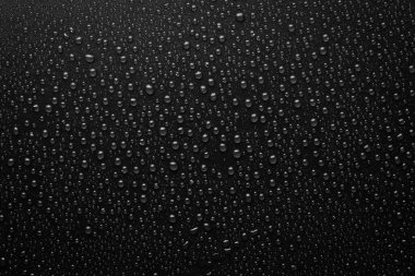 Su damlaları siyah arkaplanda. Makro. Siyah bayrak.