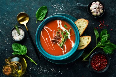 Pastırmalı, soğanlı ve kremalı domates çorbası. Meksika mutfağı. Siyah taştan bir arka planda.