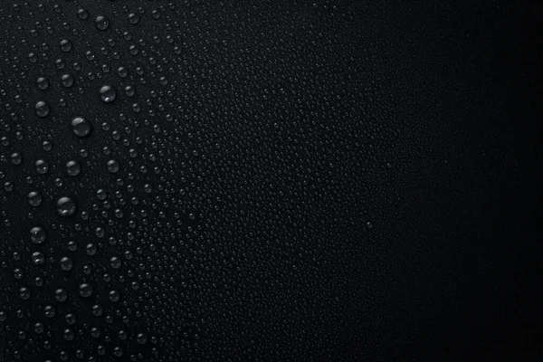 Water. Black background with raindrops. Macro. Top view.