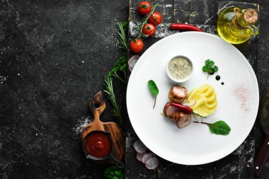 Kızarmış sosis ve patates püresi tabakta sos. Üst Manzara. Metin için boş alan.