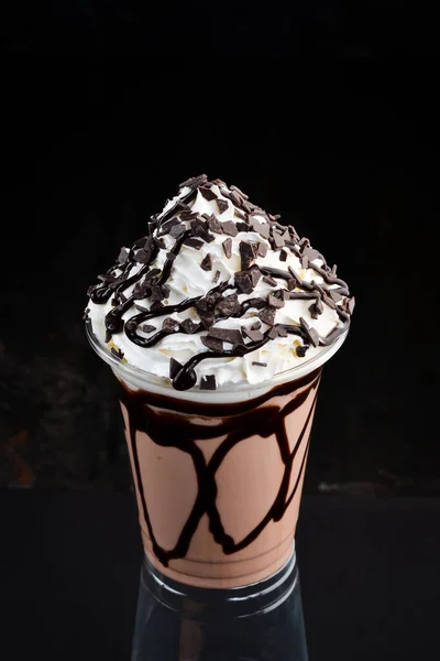 在塑料杯里的巧克力奶昔 在黑色的背景上 文件的自由篇幅 — 图库照片