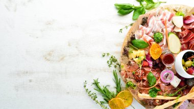 Aperatifler: peynir, jambon, salam, domuz pastırması, zeytin ve ahşap kapari. Üst Manzara. Metin için boş alan.