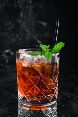 Viski kokteyli, siyah arka planda klasik bir alkollü içecek. Bar menüsü.