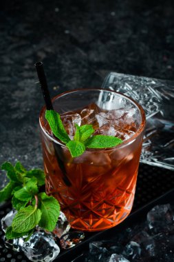 Viski kokteyli, siyah arka planda klasik bir alkollü içecek. Bar menüsü.