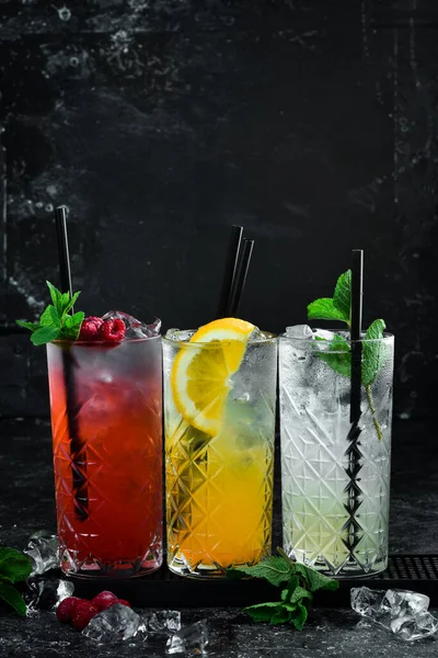 Set of colored cocktails. A set of lemonades. Bar counter with drinks. Banner. On a black background.