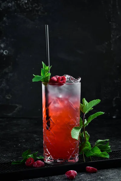A cooling drink. Raspberry lemonade with tonic, ice and mint in a glass. Cocktails. Bar menu.