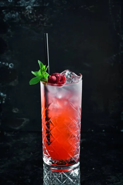 A cooling drink. Raspberry lemonade with tonic, ice and mint in a glass. Cocktails. Bar menu.