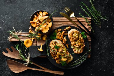 Chanterelle mantarlı ve soğanlı Taş bir tabakta. Metin için boş alan.