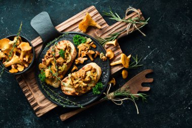 Chanterelle mantarlı ve soğanlı Taş bir tabakta. Metin için boş alan.