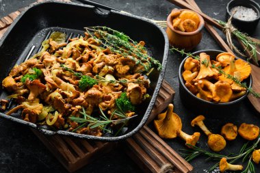 Mutfak masasındaki tavada soğan ve baharatla kızartılmış Chanterelle mantarları. Üst Manzara. Metin için boş alan.