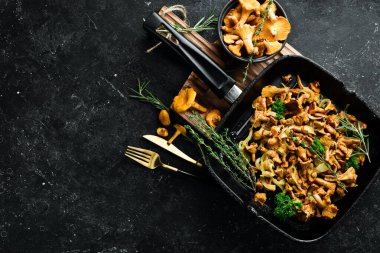 Mutfak masasındaki tavada soğan ve baharatla kızartılmış Chanterelle mantarları. Üst Manzara. Metin için boş alan.