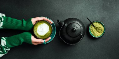 Yeşil çay, beyaz seramik bardakta sıcak matcha latte ve tarçınlı çay tabağı. Japon sütlü içeceği..