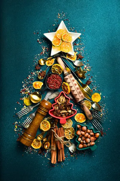 Noel kartı. Mutfak aksesuarlarından yapılmış Noel ağacı. Karanlık bir arka planda. Üst görünüm.