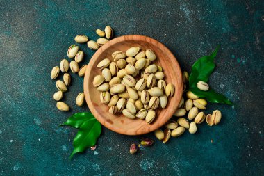 Ahşap bir kasede kavrulmuş tuzlu şam fıstığı. Üst Manzara. Boş kopyalama alanı.