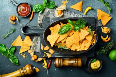 Bir kase Meksika cipsi. Tortilla cipsi. Siyah kasede taco cipsi. Mısır cipsi. Üst görünüm.