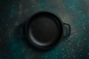 Demir metal tava. Koyu yeşil turkuaz bir arka planda. Metin için boş alan.