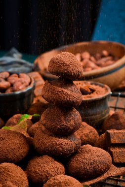 Çikolatalı trüf ve kakao tozu. Koyu çikolata arka planında. Kakao çekirdeği..