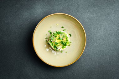 Sebzeli ve mayonezli ton balığı salatası. Siyah taştan bir arka planda. Bir tabakta, yakın plan..