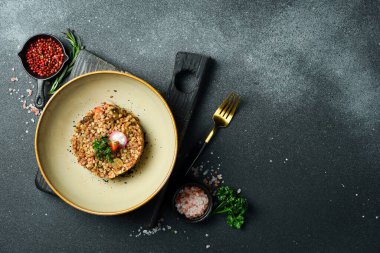 Mantarlı ve domatesli haşlanmış karabuğday. Sağlıklı yiyecekler. Beslenme düzeni. Karanlık bir taş arka planda.