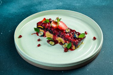 Böğürtlen reçelli kaz ezmesi. Tabakta yemek servisi yapan bir restoran. Siyah taştan bir arka planda. Metin için boş alan.