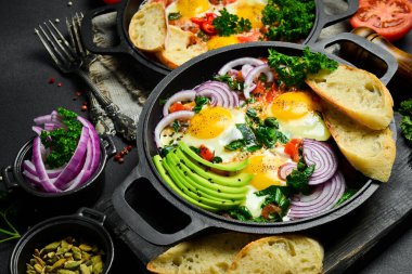 Shakshuka kızartma tavasında. Sağlıklı, lezzetli bir kahvaltı. Üst manzara, genel giderler, düz yatış. Geleneksel Yahudi omleti..