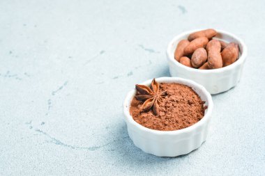 Cocoa and cocoa beans in a white bowl. On a gray stone background. Side view. clipart