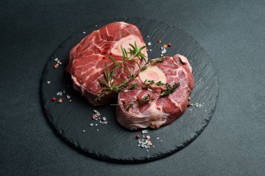 Siyah tabakta iki çiğ Ossobuco bifteği. Barbekü. Siyah bir arka planda. Tarif için boş alan.