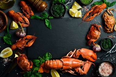 Istakoz. Banner, mesaj için boş yer. Izgara ıstakoz, yengeç ve kerevit. Siyah tahtada limon ve fesleğen..