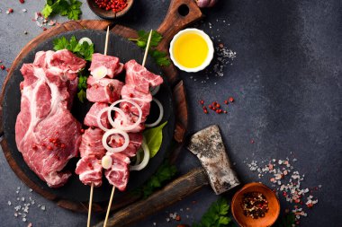 Baharatlı ve otlu kebap, domuz eti seti, gri masa arkasında. Kapat..