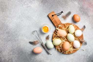 Çiğ tavuk yumurtası ve tahta bölme tahtası. Hafif beton arka planda.