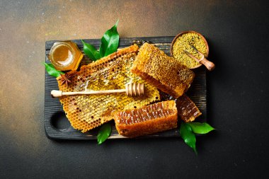 Tahta bir tahtanın üzerinde bal dolu bal petekleri. Taze organik bal.