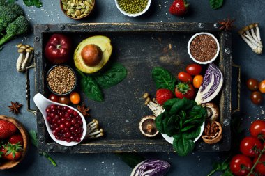 Üst manzara, meyve, böğürtlen ve sebzeli ahşap kutu. Metin için alanı olan çerçeve. Karanlık bir taş arka planda.