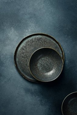 Koyu renk seramik kaplar ve tabaklar. Gri beton arkaplanı kapatın. Metin için boş alan.