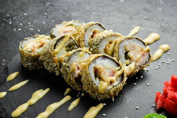 Klasik suşi tempura balıklı rulo. Japon yemeği. Siyah taştan bir arka planda. Üst görünüm.