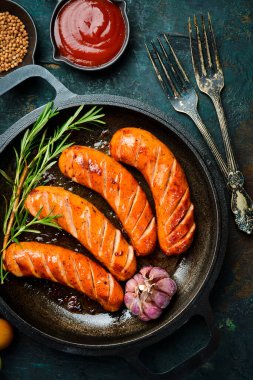 Demir tava ve kızarmış domuz sosisi. Üst Manzara. Barbekü veya ızgara arkaplanı.