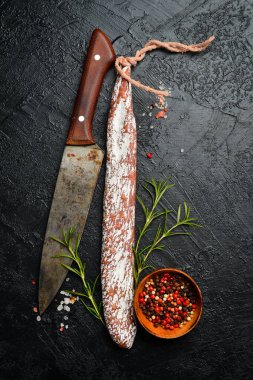 İspanyol salamı fuet sosisi ya da mayalanmış sosis. Siyah bir arkaplanda. Üst Manzara. Metin için boş alan.