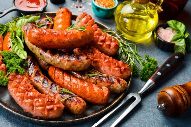 Büyük bir tabak domuz eti, sığır eti ve tavuk sosisi. Üst Manzara, kapat. Gri taştan bir arka planda.