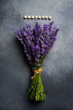 Bir demet lavanta çiçeği. Gri beton arka planda mis kokulu mor çiçekler. Üst görünüm.